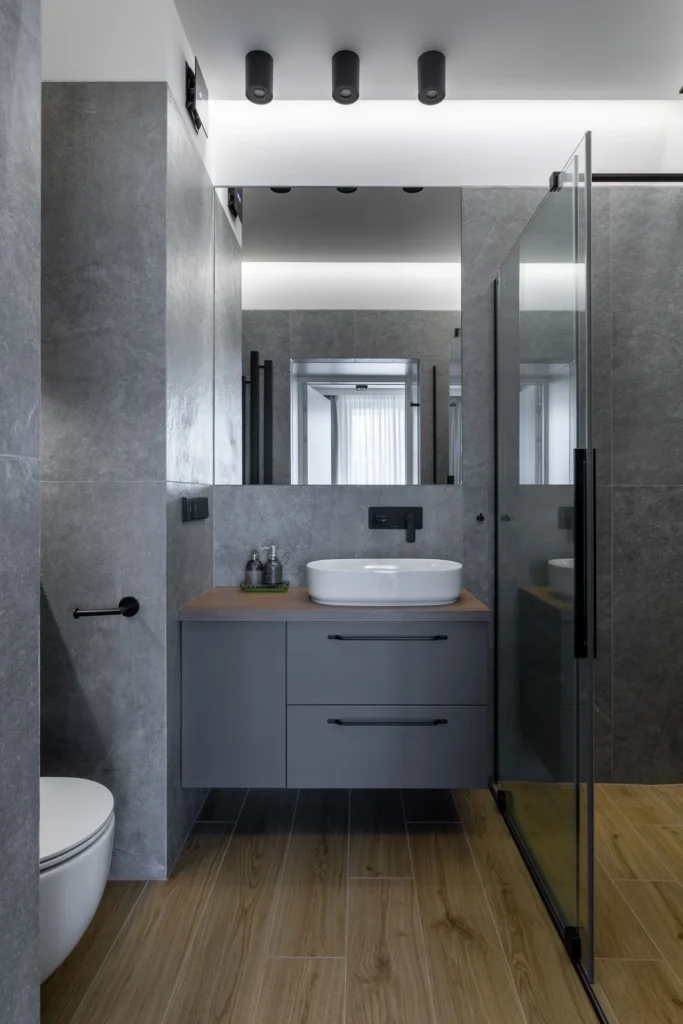 nowoczesna-łazienka-apartament-warszawa-kabaty-5 nowoczesna łazienka z prysznicem walk in, szare płytki i podwieszana szafka, minimalistyczny design