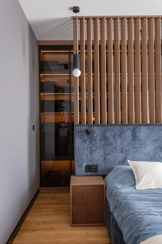 nowoczesna-sypialni-apartament-warszawa-kabaty-4 nowoczesna sypialnia z drewnianą ścianką ażurową i tapicerowanym zagłówkiem, przytulne wnętrze